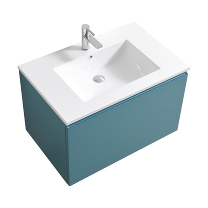A wall-mounted bathroom vanity with a teal green cabinet and a white integrated sink, without handles.